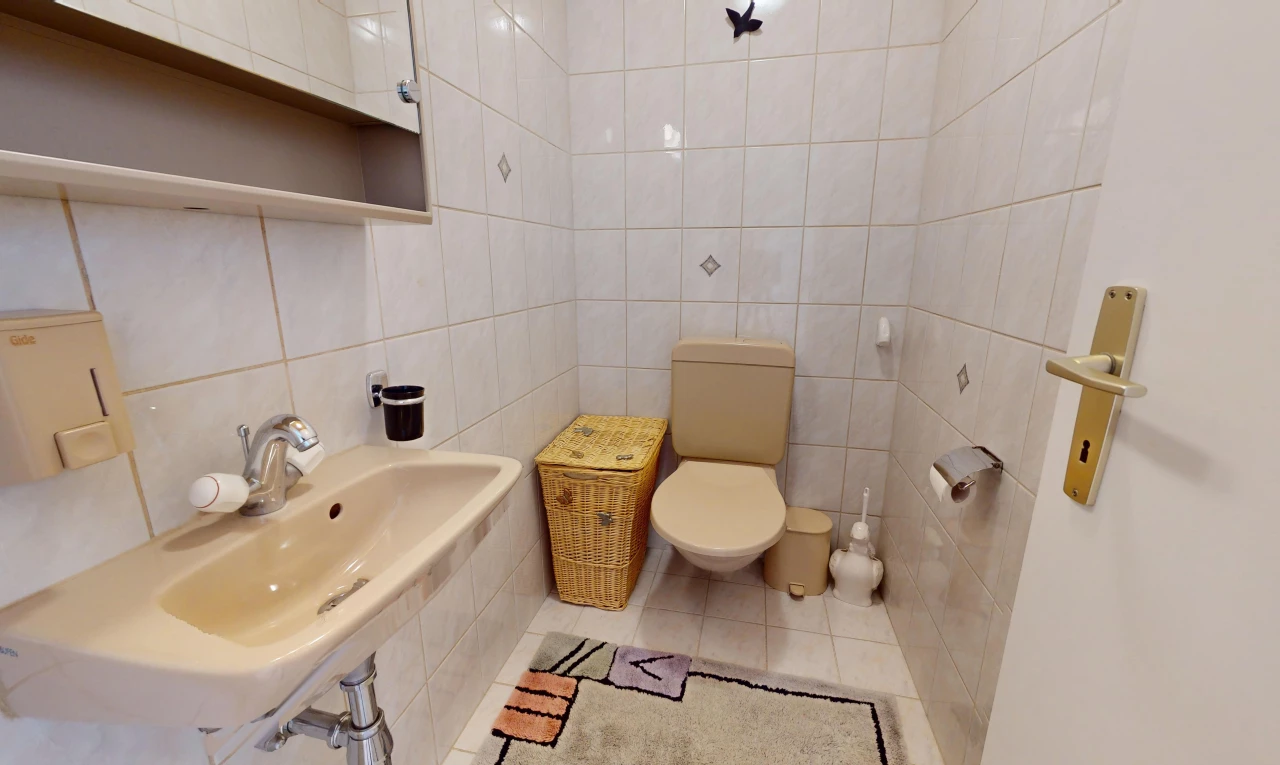 salle de bain avec mur carrelé, vasque, carrelage, et miroir