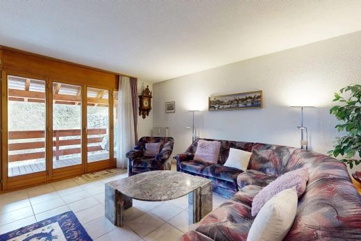 salon avec lumière naturelle, carrelage, et plafond voûté