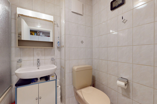 salle de bain avec mur carrelé, miroir, et vasque