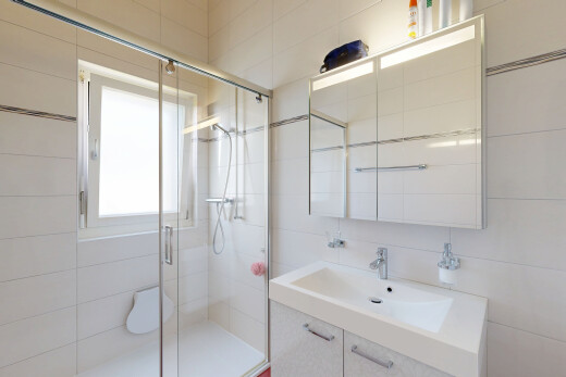 bathroom featuring a shower stall, vanity, and tile walls