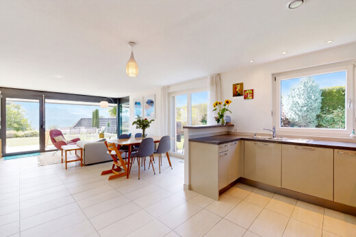 kitchen featuring access to outside, dark countertops, a peninsula, and pendant lighting