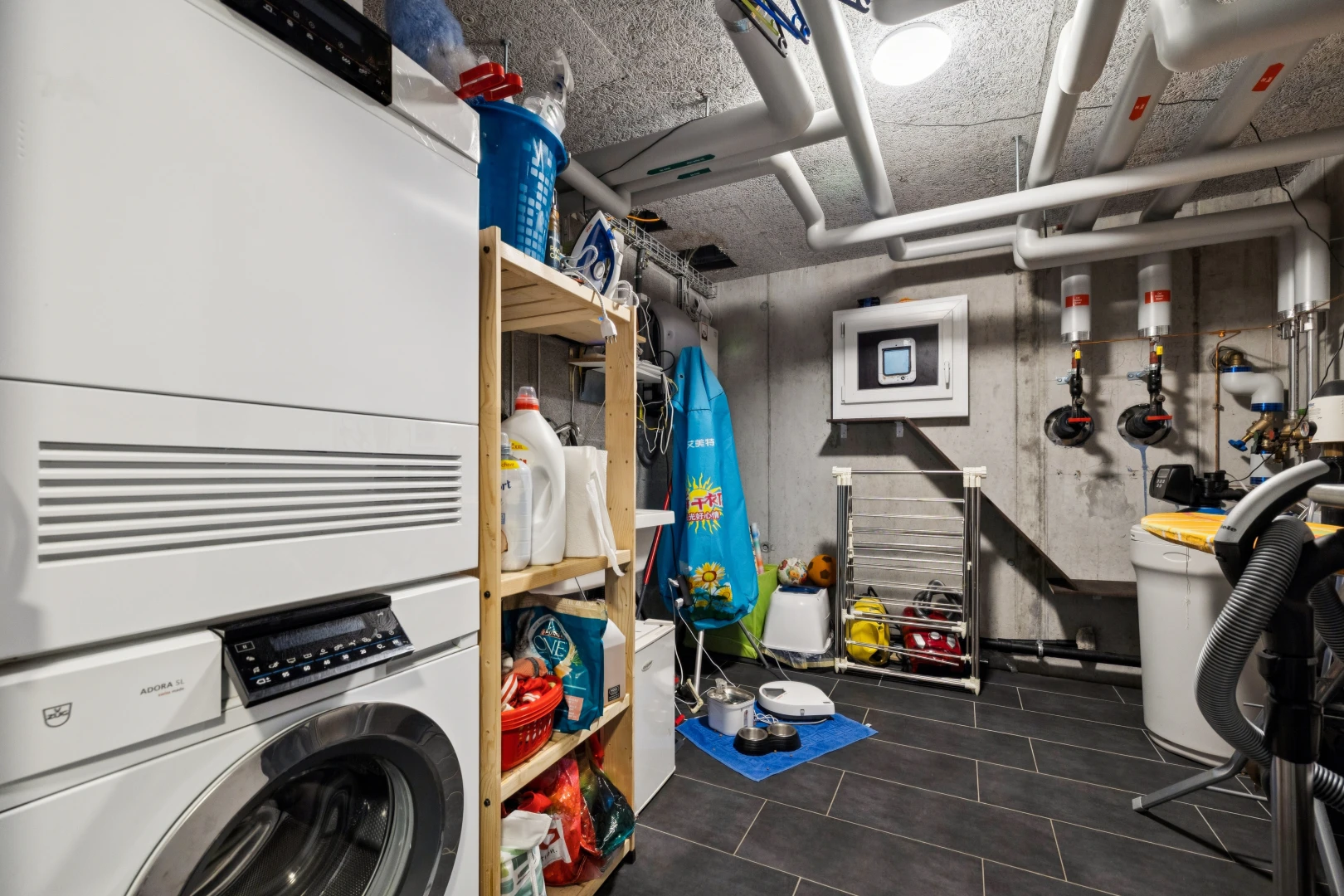 buanderie avec sous-sol, lave-linge et sèche-linge, buanderie, dark floor, et inside property