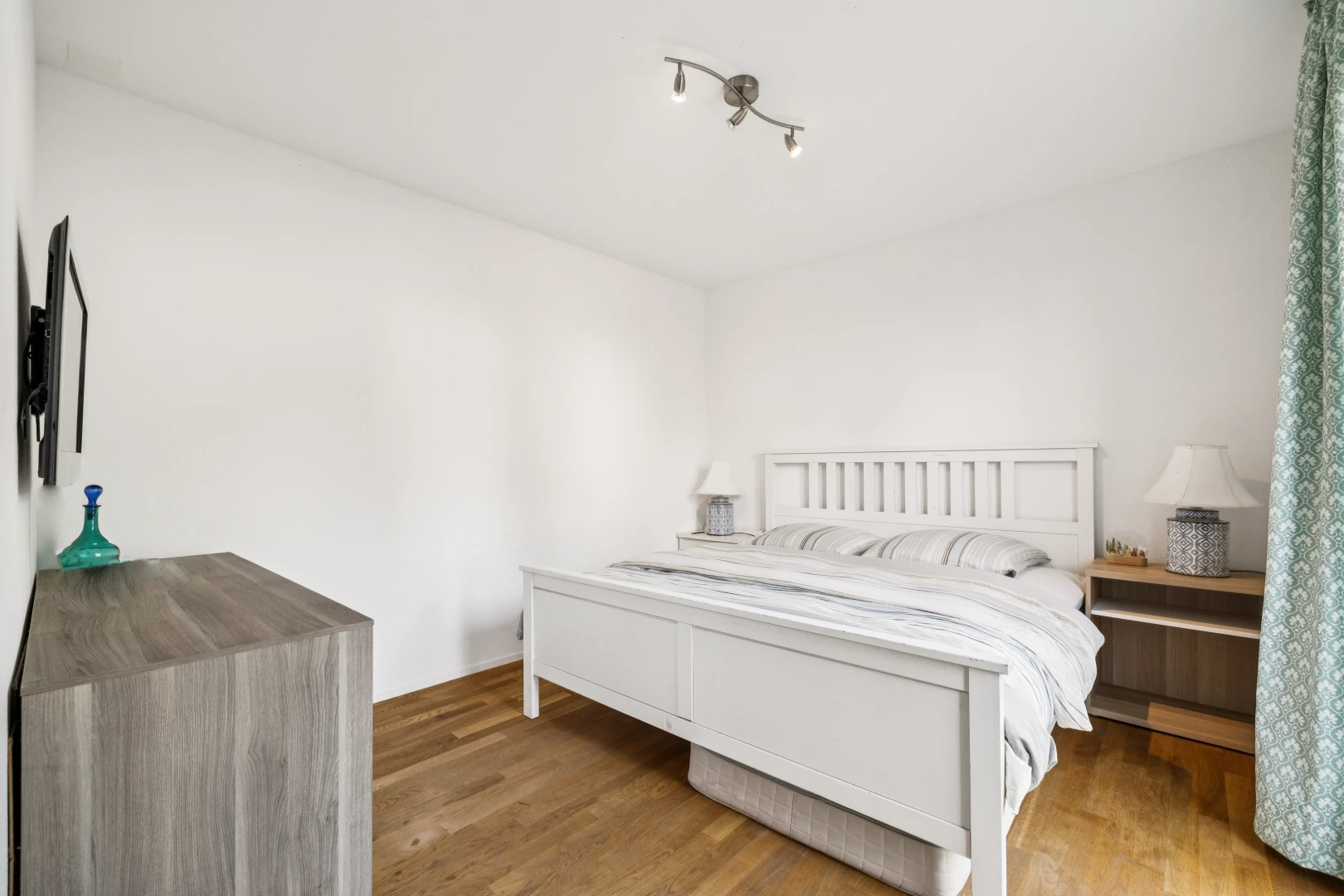 chambre avec éclairage sur rail, wood finish floor, sol en finition bois, drywall, et cloison sèche