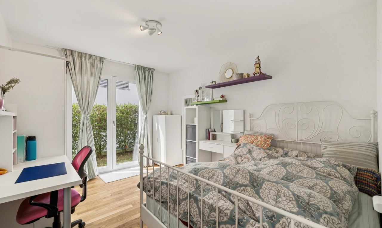 chambre avec espace bureau, accès à l'extérieur, drywall, cloison sèche, et wood finish floor
