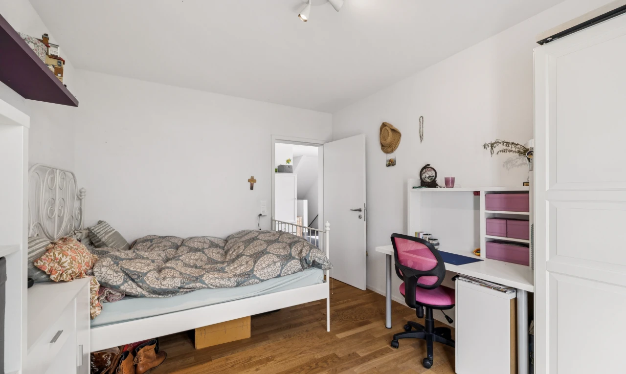 chambre avec cloison sèche, drywall, espace bureau, sol en finition bois, et wood finish floor