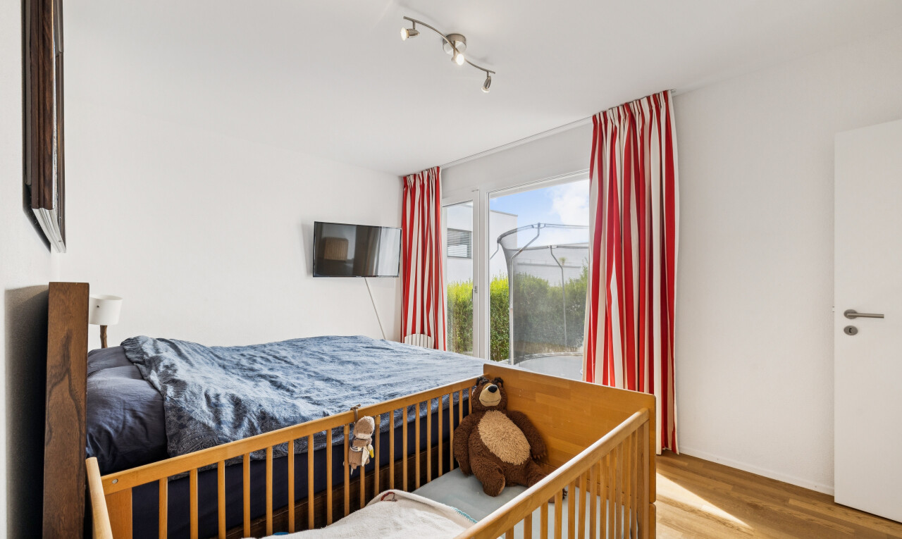 zimmer / schlafzimmer mit deckenbeleuchtung, drywall, gipskartonwand, fernseher, und wood finish floor