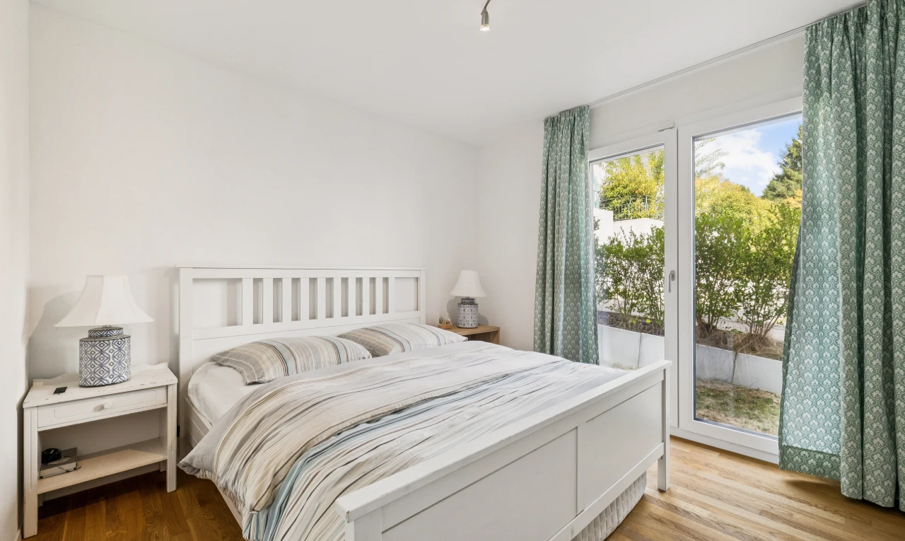 chambre avec éclairage sur rail, accès à l'extérieur, wood finish floor, sol en finition bois, et drywall