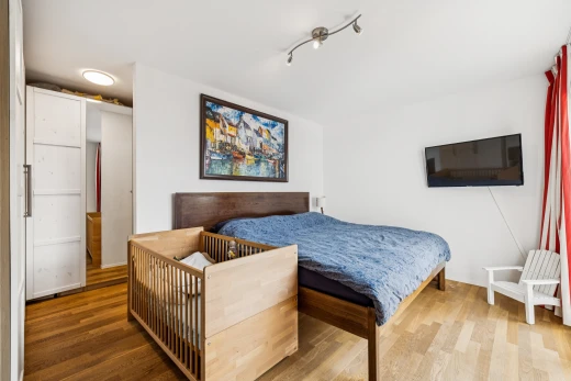 chambre avec télévision, drywall, cloison sèche, wood finish floor, et sol en finition bois