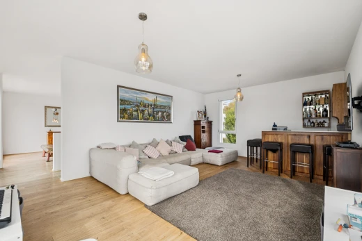 salon avec éclairage suspendu, bar intérieur, sol en finition bois, wood finish floor, et cloison sèche