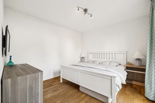 chambre avec éclairage sur rail, wood finish floor, sol en finition bois, drywall, et cloison sèche