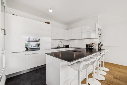 cuisine avec dark countertops, plans de travail, dark floor, flat panel cabinets, et armoires à panneau plat