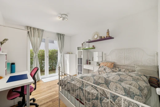 chambre avec espace bureau, accès à l'extérieur, drywall, cloison sèche, et wood finish floor