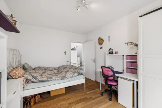 chambre avec cloison sèche, drywall, espace bureau, sol en finition bois, et wood finish floor