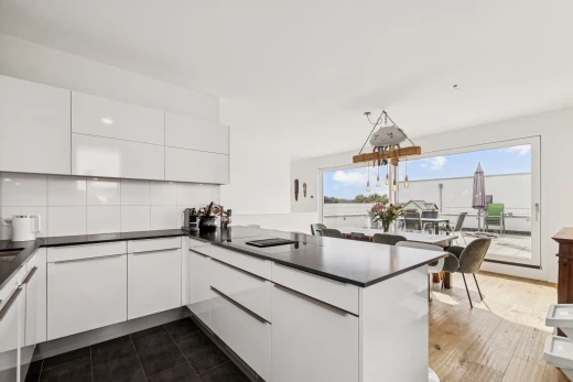 cuisine avec armoires à panneau plat, flat panel cabinets, plans de travail, dark countertops, et dark floor