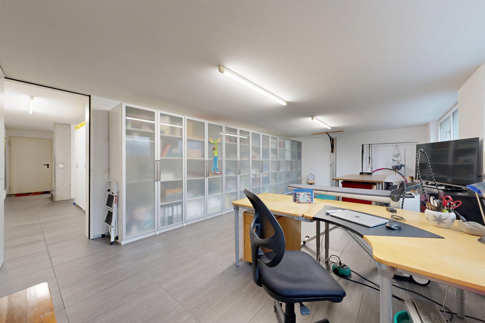 bureau avec inside community, télévision, drywall, espace bureau, et light floor
