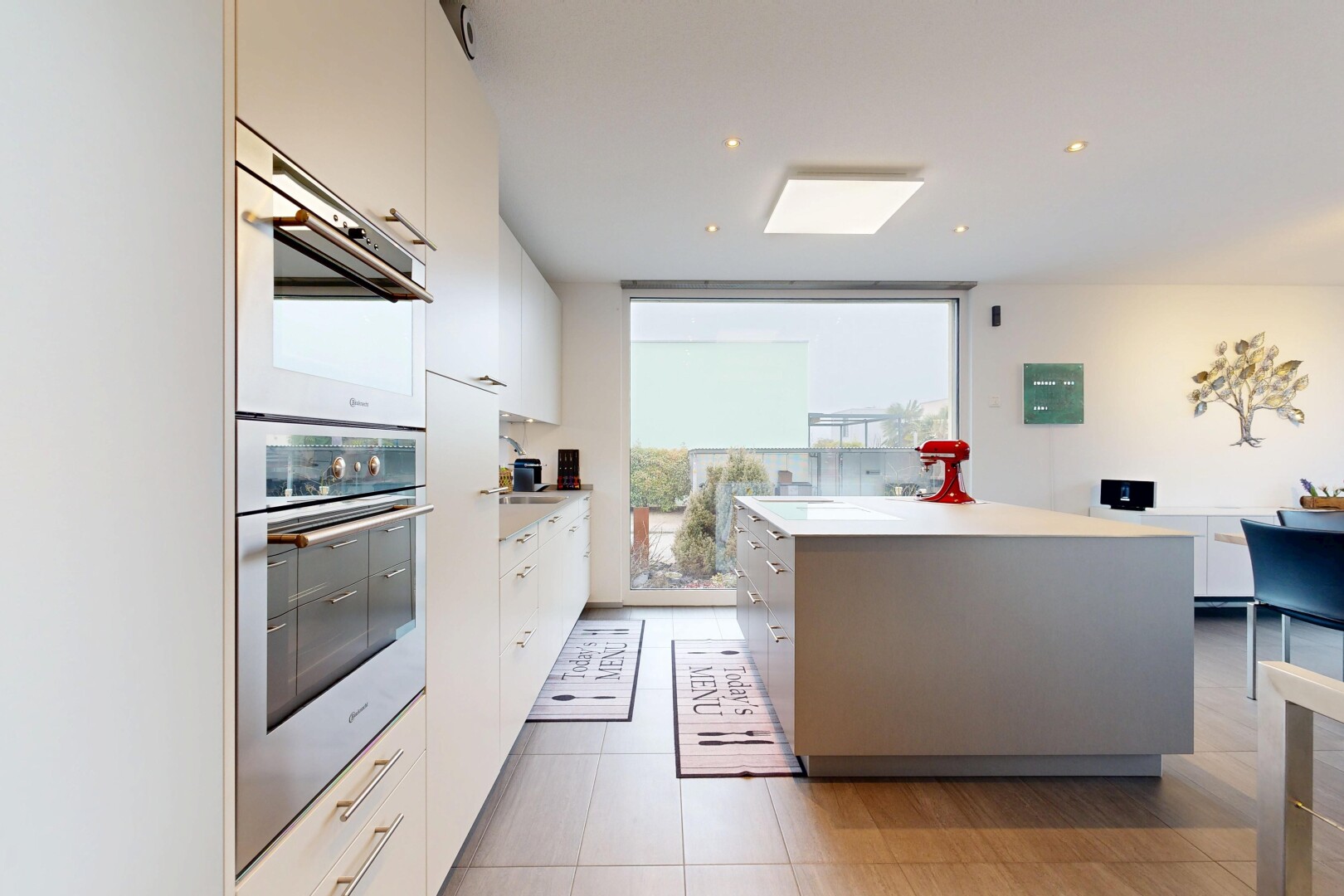 cuisine avec four double, floor ceiling windows, plans de travail, light countertops, et drywall