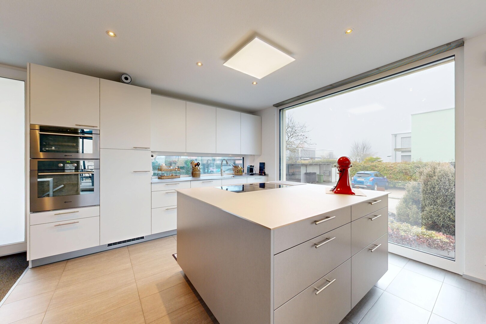cuisine avec armoires à panneau plat, flat panel cabinets, îlot de cuisine, kitchen island, et light floor
