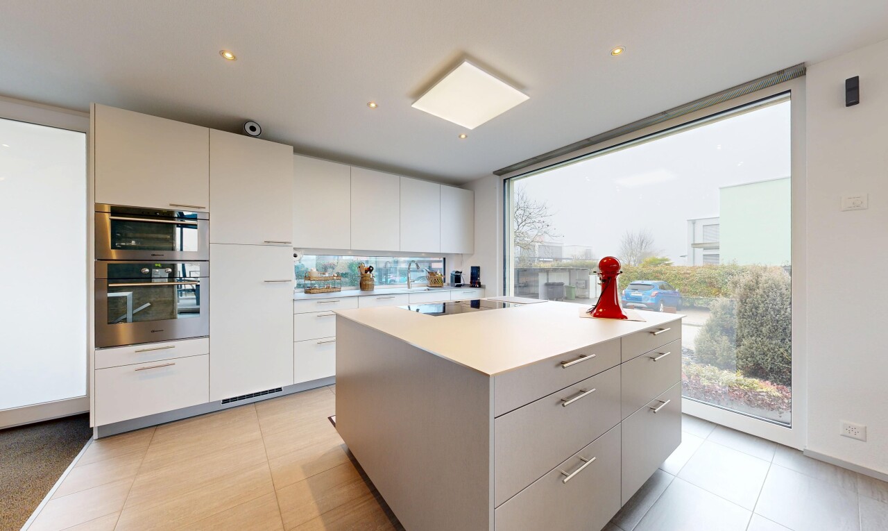 cuisine avec armoires à panneau plat, flat panel cabinets, îlot de cuisine, kitchen island, et light floor