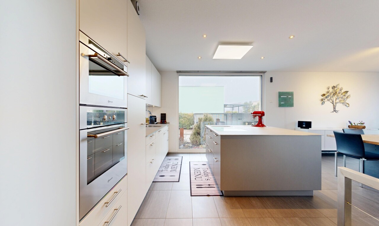 cuisine avec four double, floor ceiling windows, plans de travail, light countertops, et drywall
