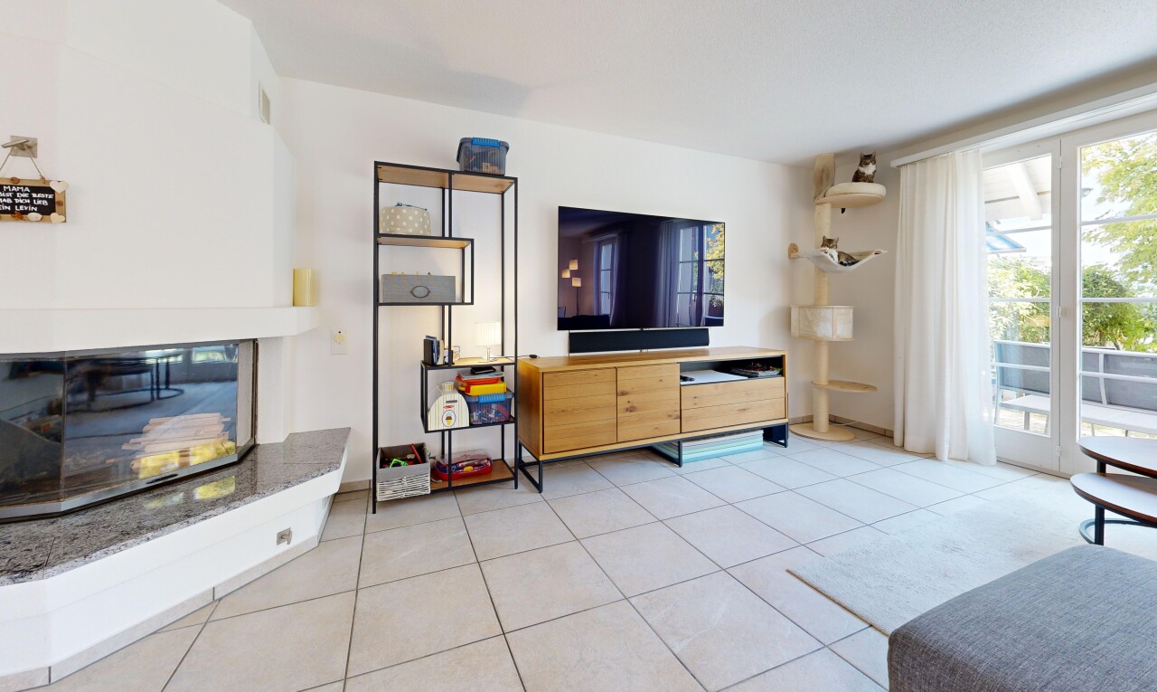 wohnzimmer mit fernseher, gipskartonwand, drywall, fliesenboden, und tile floor