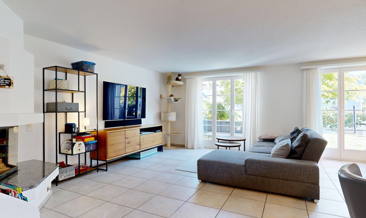 wohnzimmer mit fernseher, gipskartonwand, drywall, fliesenboden, und tile floor