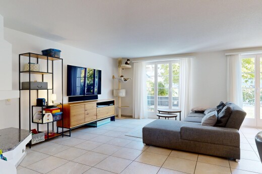 wohnzimmer mit fernseher, gipskartonwand, drywall, fliesenboden, und tile floor