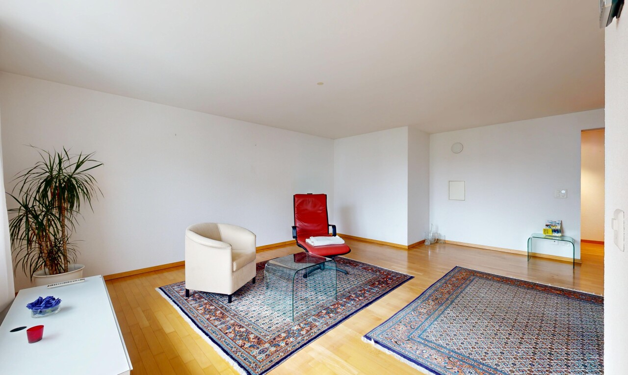 salon avec cloison sèche, drywall, inside property, sol en finition bois, et wood finish floor