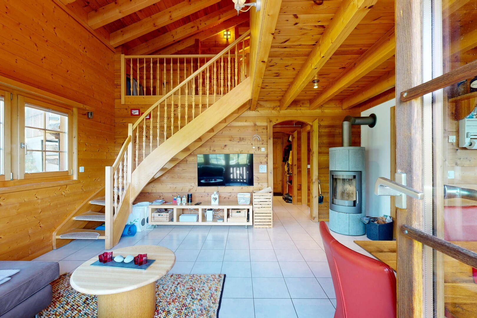 salon avec escaliers, wood wall, mur en bois, beamed ceiling, et light floor