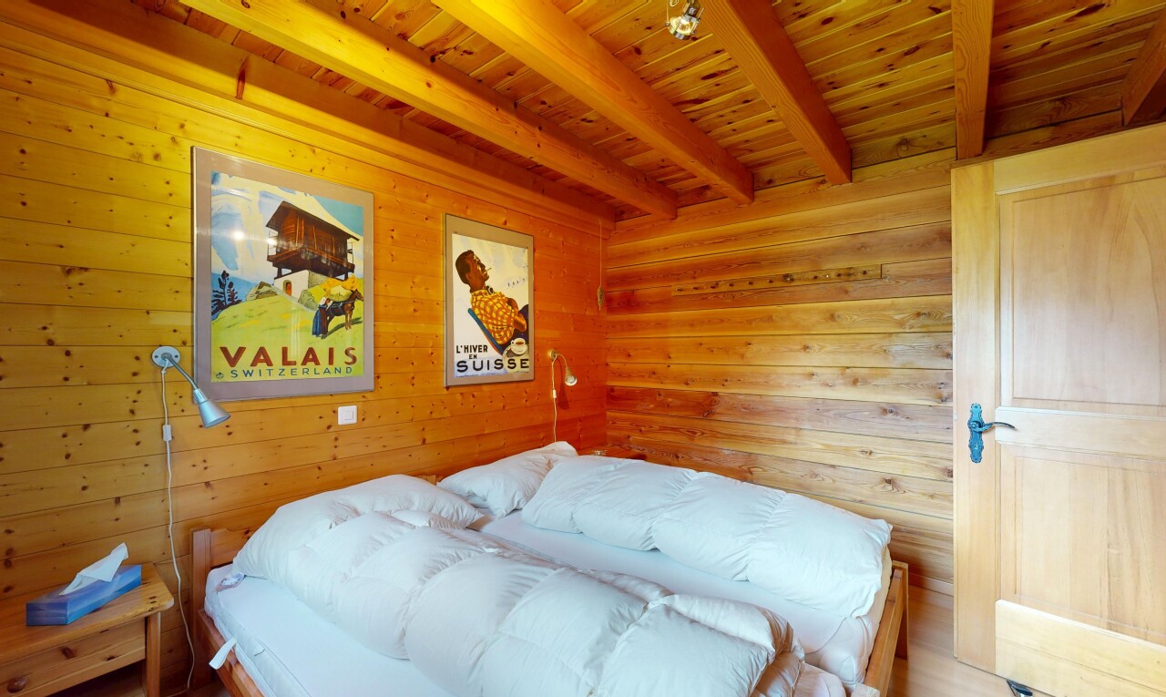 chambre avec beamed ceiling, plafond à poutres, wood wall, mur en bois, et wood ceiling