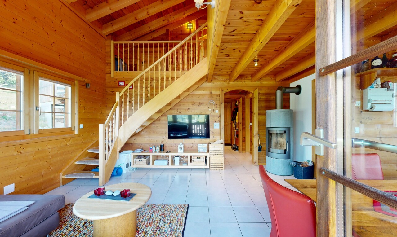 salon avec escaliers, wood wall, mur en bois, beamed ceiling, et light floor