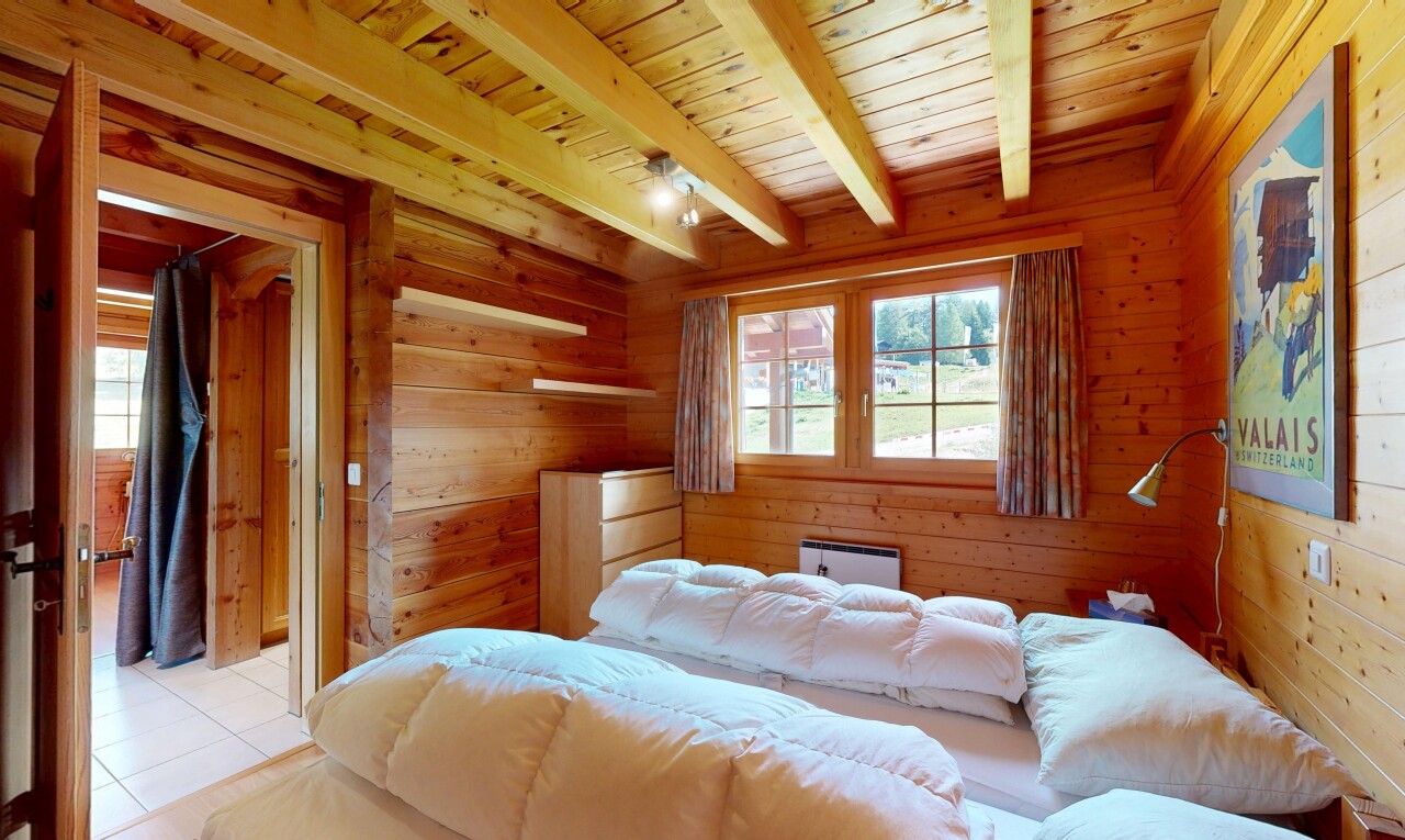 chambre avec beamed ceiling, plafond à poutres, high end ceiling, wood wall, et mur en bois