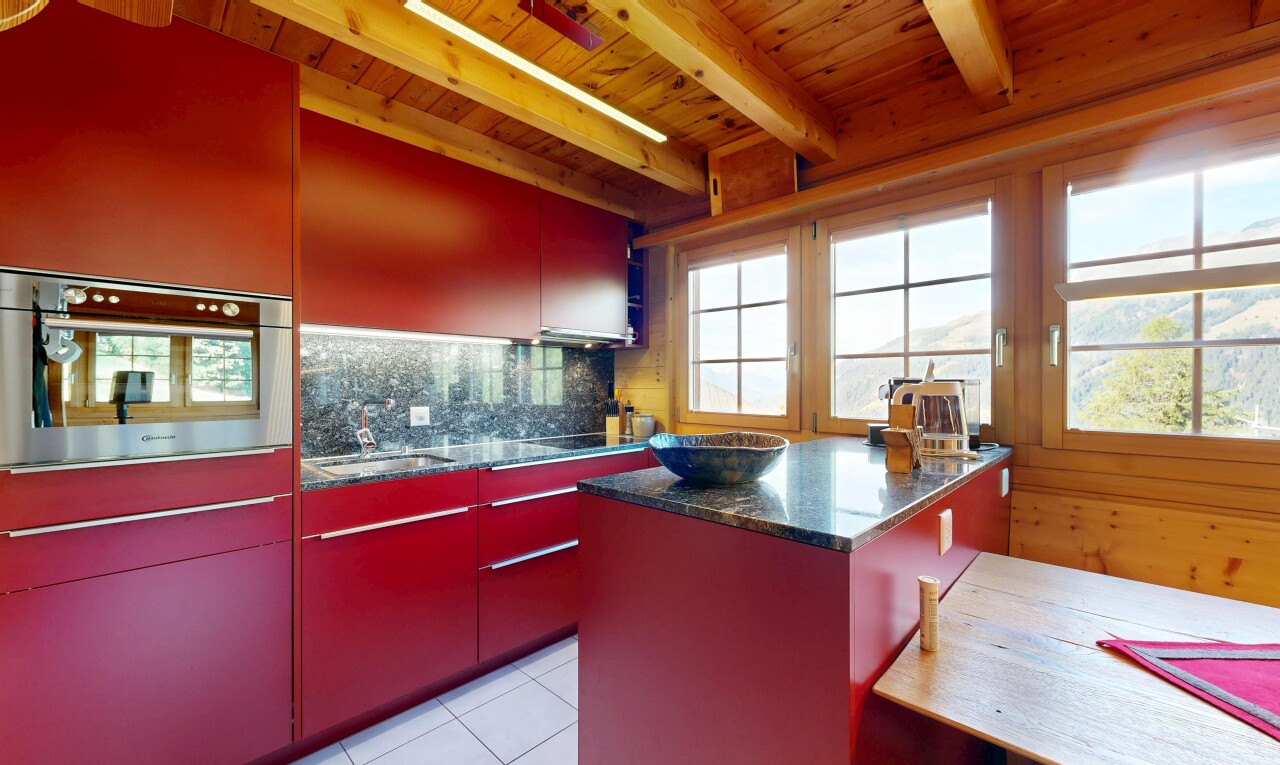 cuisine avec dark countertops, light floor, beamed ceiling, plafond à poutres, et stone countertops