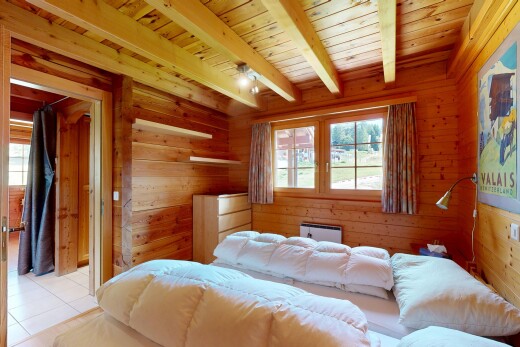 zimmer / schlafzimmer mit beamed ceiling, balkendecke, high end ceiling, wood wall, und holzwand