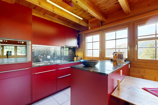 cuisine avec dark countertops, light floor, beamed ceiling, plafond à poutres, et stone countertops