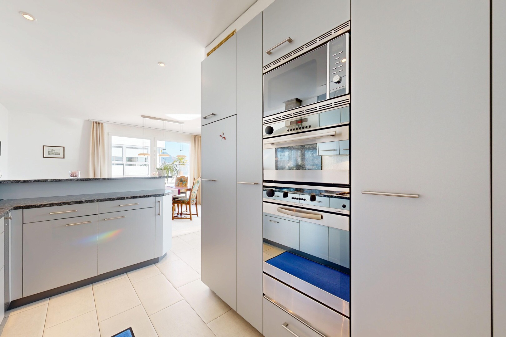 küche mit mikrowelle, natürliches licht, natural light, graue schränke, und gray cabinets