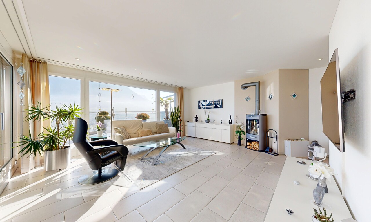 wohnzimmer mit inside property, fernseher, natürliches licht, natural light, und holzofen