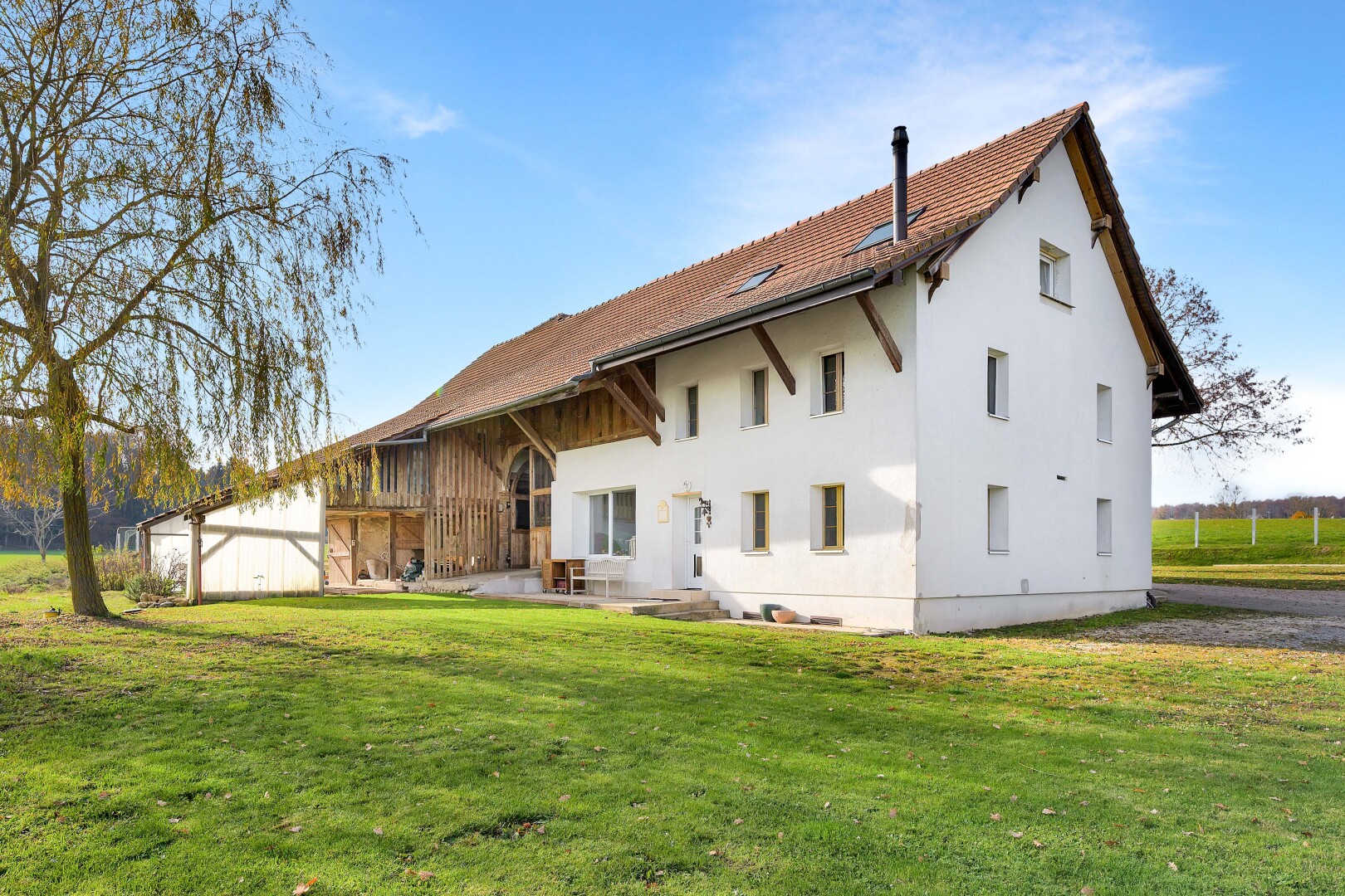 façade avec property visible, pelouse, day time, terrasse, et bardage en stuc