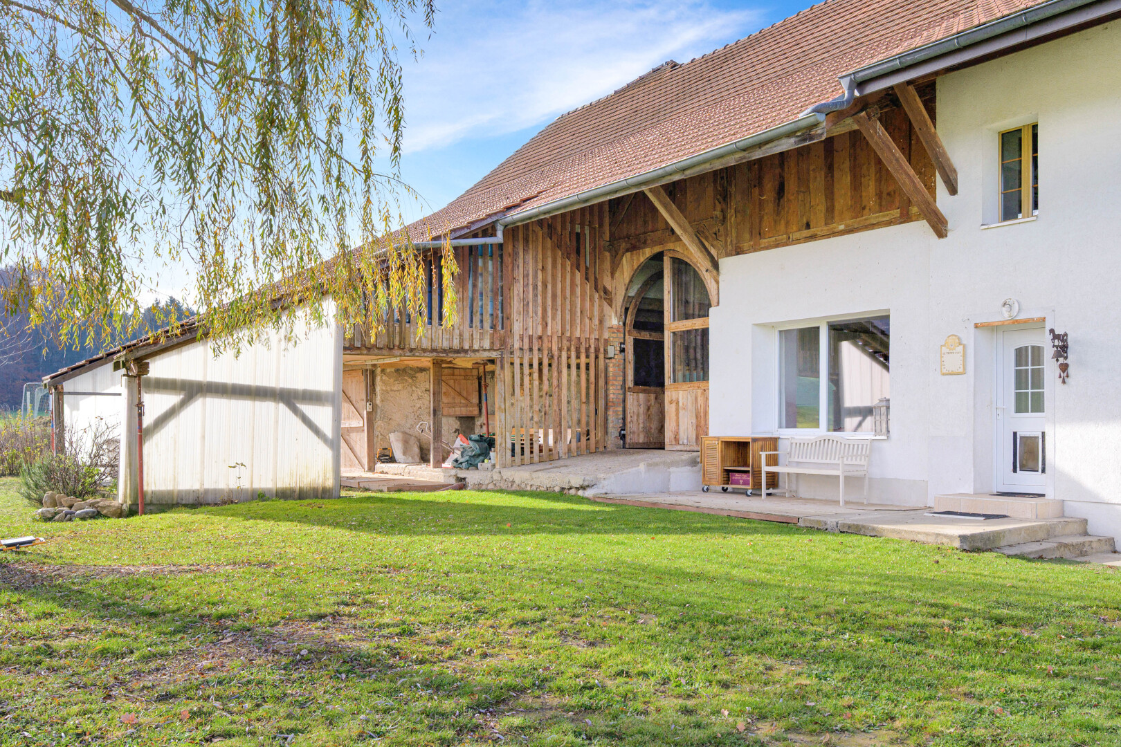 façade avec property visible, day time, terrasse, pelouse, et bardage en stuc