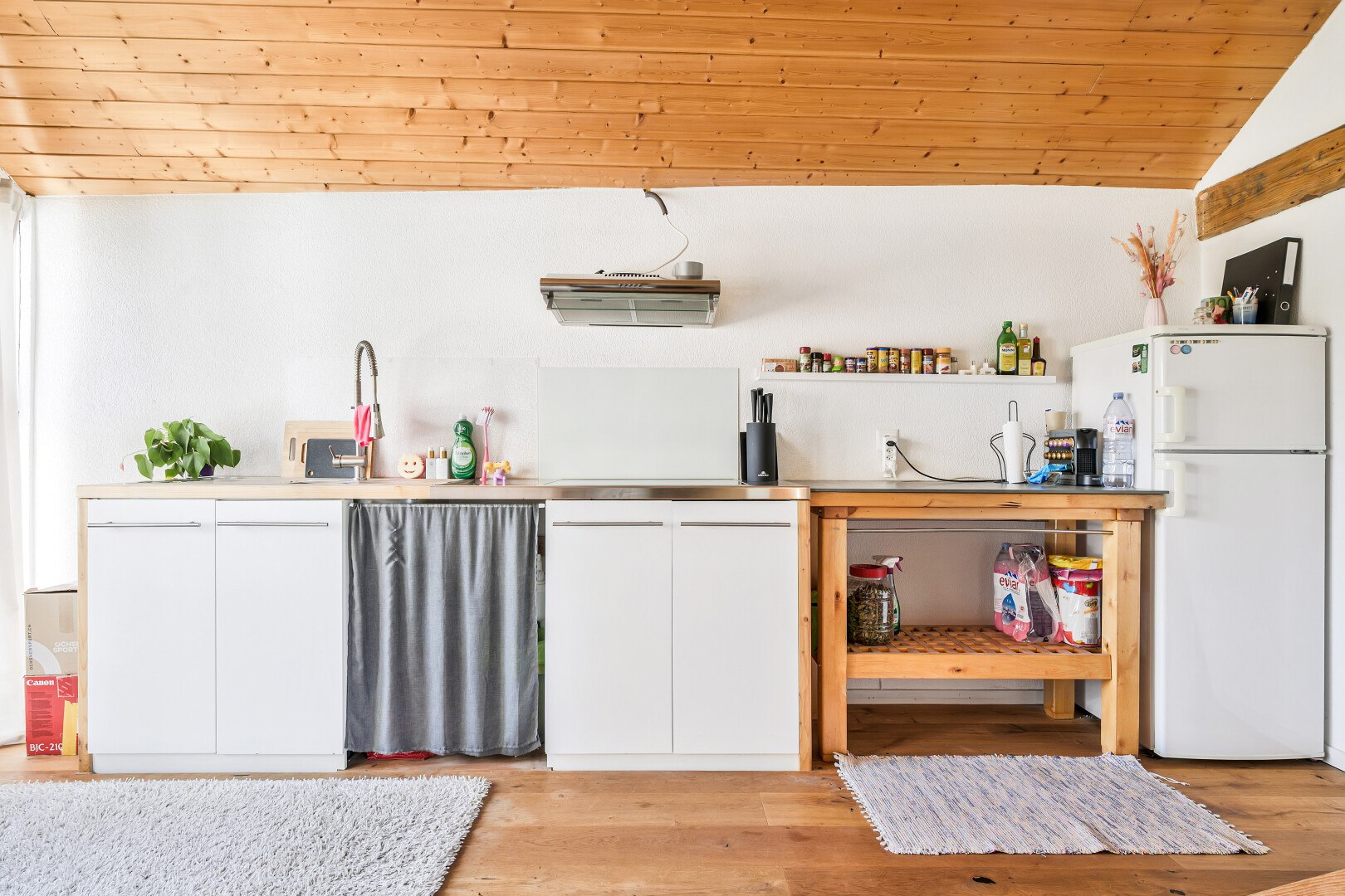 cuisine avec armoires blanches, réfrigérateur, inside property, wood finish floor, et sol en finition bois