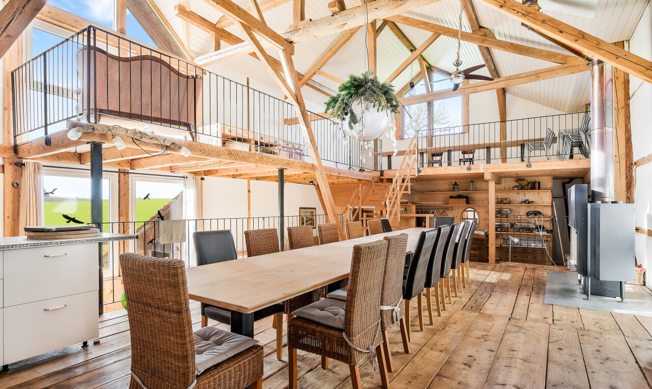 dining room with high vaulted ceiling and hardwood / wood-style flooring