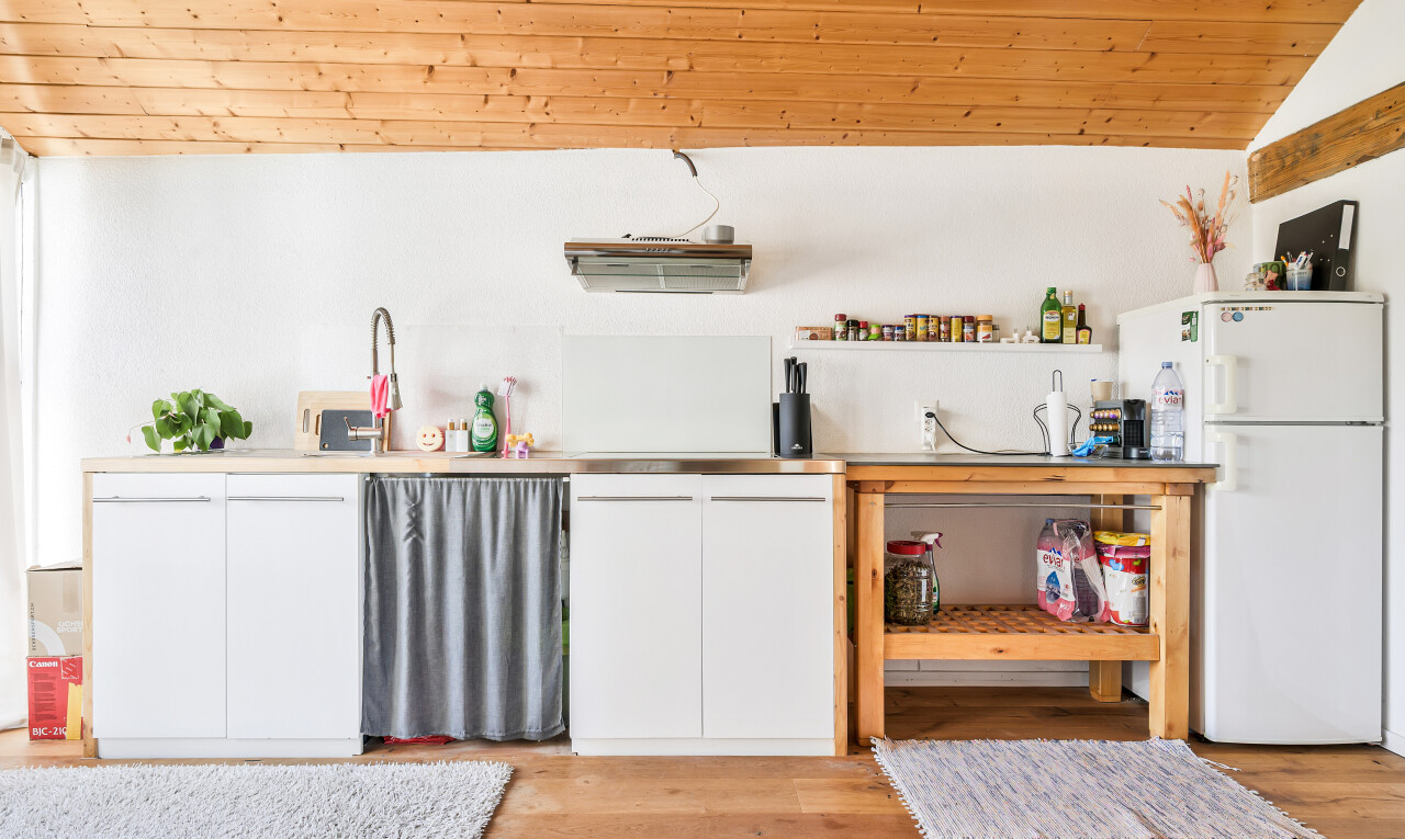 kitchen with white cabinetry, freestanding refrigerator, light wood finished floors, vaulted ceiling, and light countertops