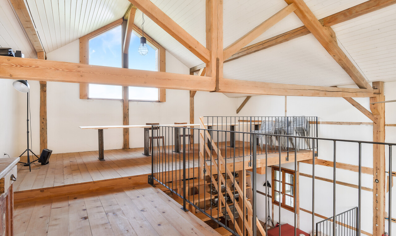 stairs with hardwood / wood-style floors, beam ceiling, and high vaulted ceiling