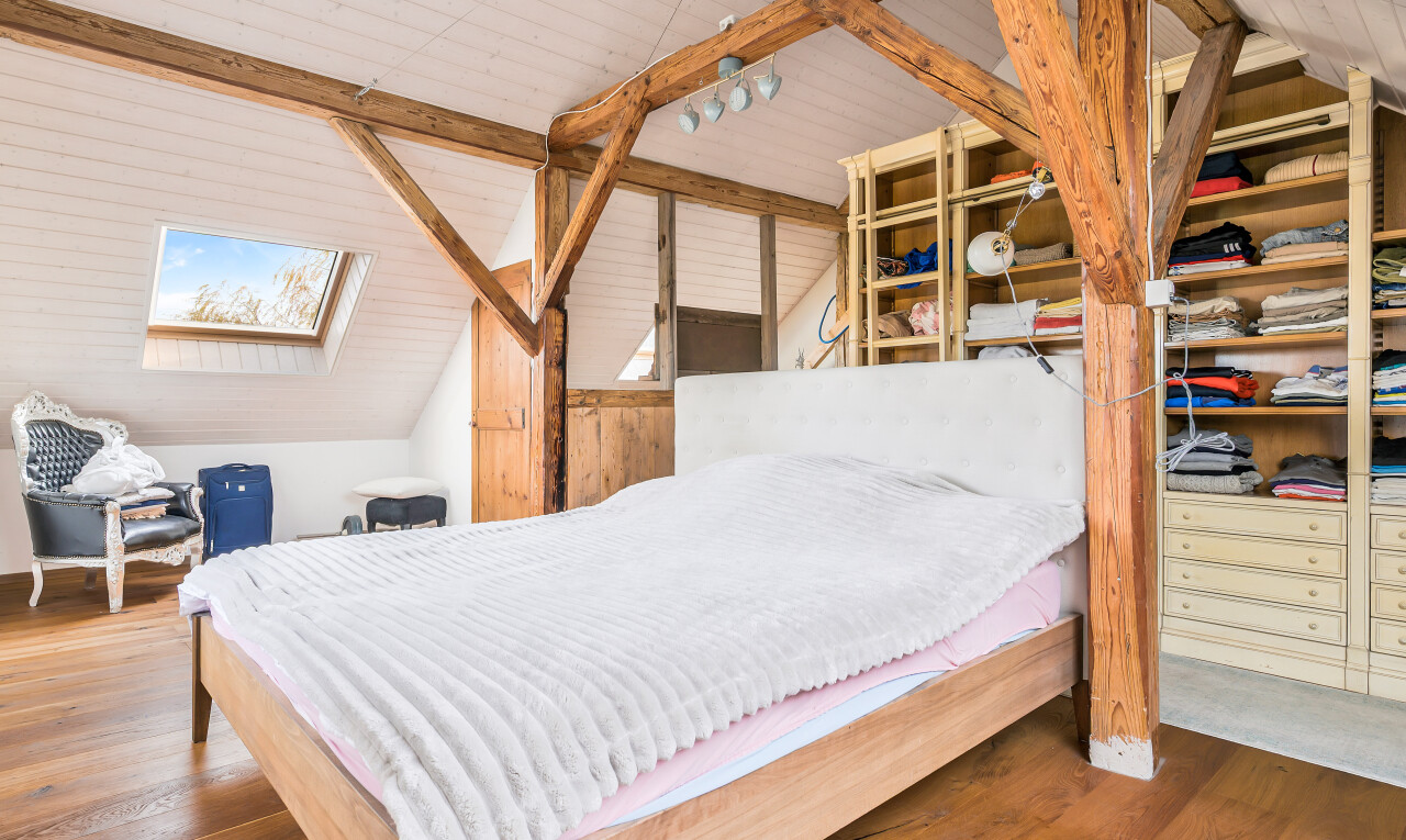 chambre avec plafond voûté, vaulted ceiling, sol en finition bois, wood finish floor, et plafond à poutres
