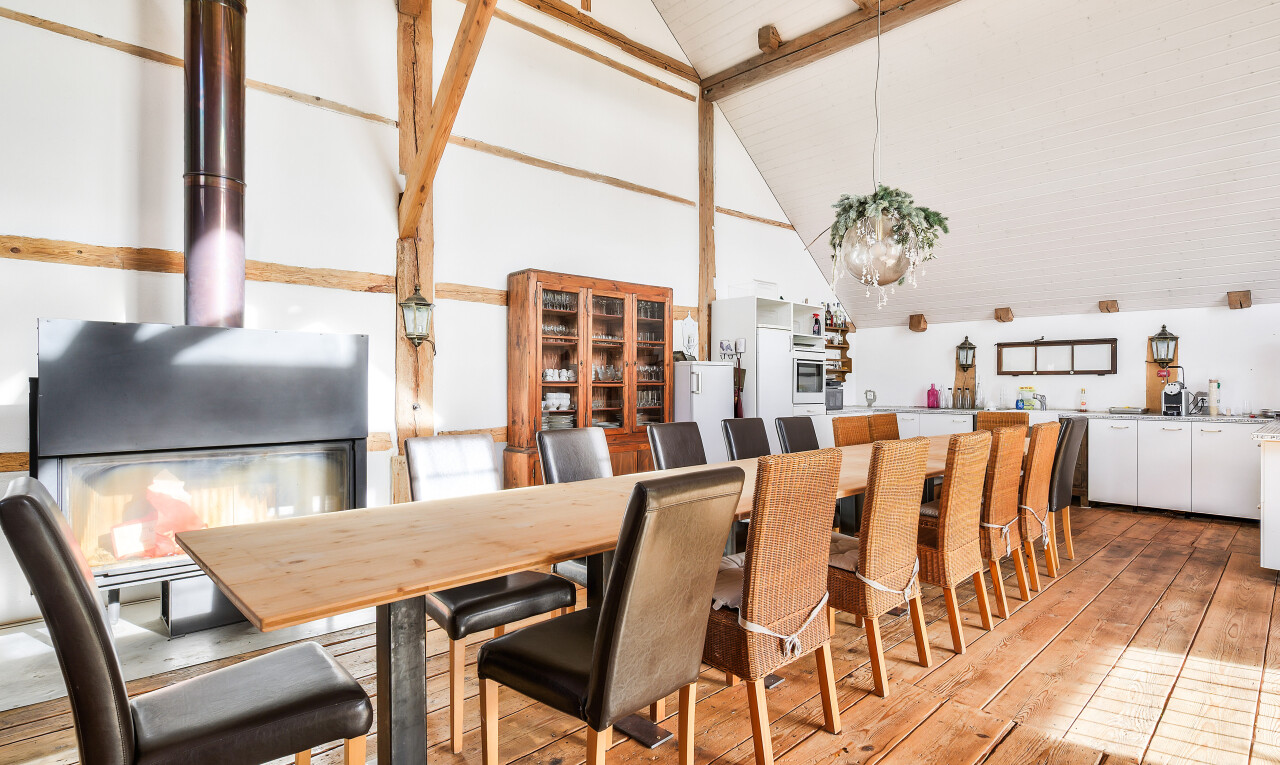 dining area with light wood-style flooring, beamed ceiling, and high vaulted ceiling