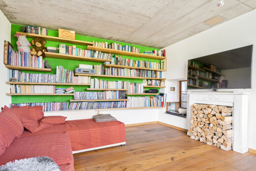 salon avec télévision, wood finish floor, sol en finition bois, inside property, et concrete ceiling
