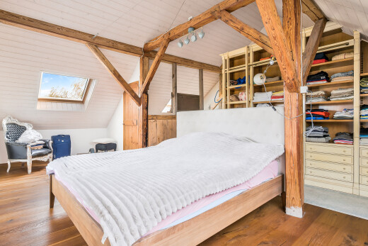 chambre avec plafond voûté, vaulted ceiling, sol en finition bois, wood finish floor, et plafond à poutres