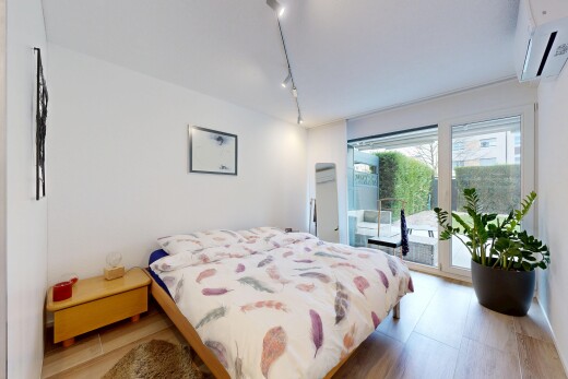 room / bedroom with access to outside, an AC wall unit, and rail lighting