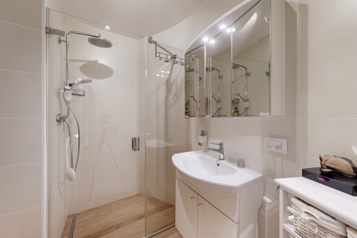 bathroom featuring a stall shower, vanity, and tile walls
