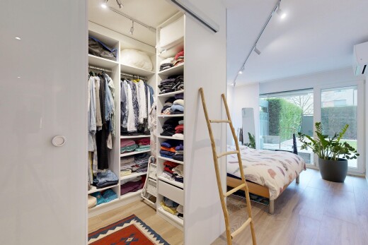 room with track lighting, light wood finished floors, access to outside, and a wall unit AC