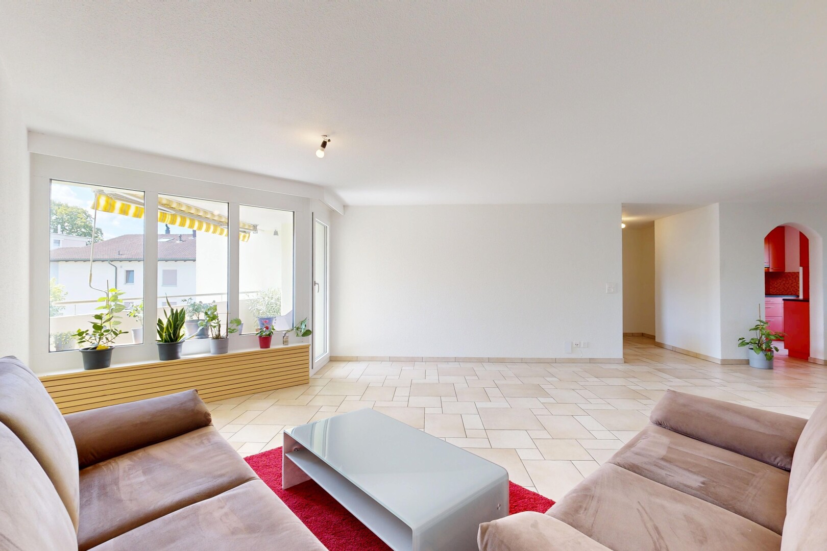salon avec passages en arc, drywall, cloison sèche, light floor, et inside property